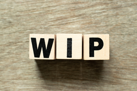 Letter block in word WIP (Abbreviation of work in progress)  on wood backgroundの写真素材