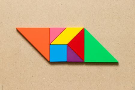 Color tangram puzzle in parallelogram shape on wood backgroundの写真素材