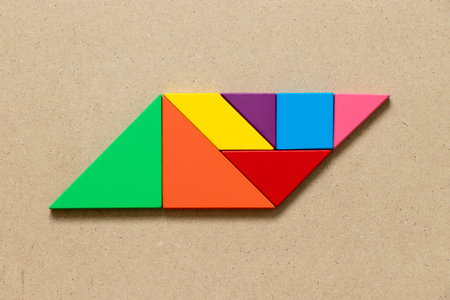 Color tangram puzzle in parallelogram shape on wood backgroundの写真素材
