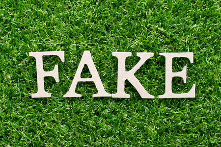 Wood alphabet in word fake on artificial green grass backgroundの写真素材