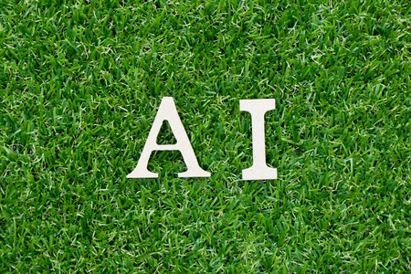 Wood letter in word AI (Abbreviation of Page artificial intelligence) on green grass backgroundの写真素材