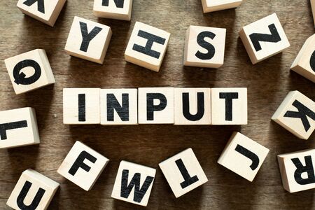 Letter block in word input with another block on wood backgroundの写真素材