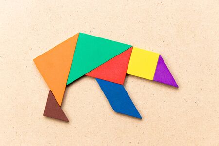 Color tangram puzzle in bear shape on wood backgroundの写真素材