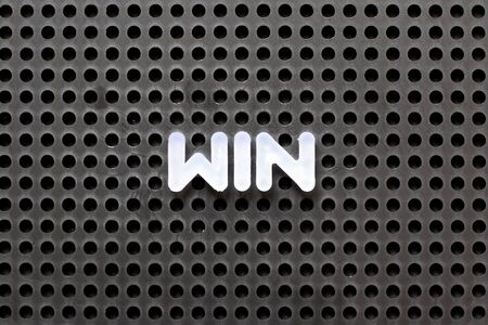Black color pegboard with white letter in word winの写真素材