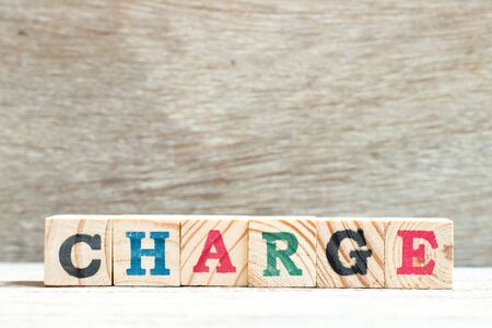 Alphabet letter block in word charge on wood backgroundの写真素材