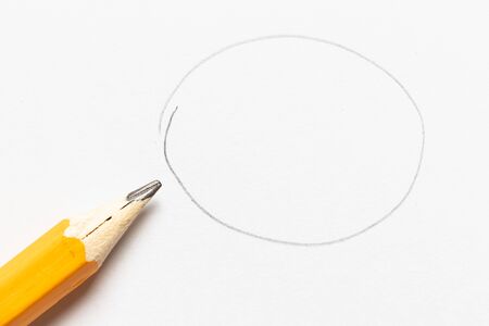 Wooden pencil with round shape drawing on white paper backgroundの写真素材