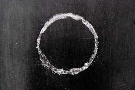 White chalk hand drawing in circle or round shape on black board backgroundの写真素材