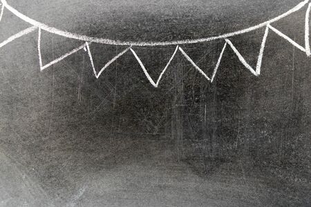 White chalk hand drawing in party flag shape on blackboard background with copy space for decoration or add textの写真素材