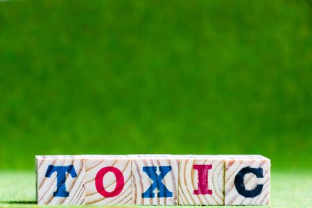 Letter block in word toxic on artificial green backgroundの写真素材