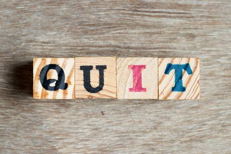 Letter block in word quit on wood backgroundの写真素材