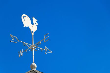 White rooster weather vane show the wind direction on blue sky backgroundの写真素材