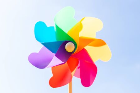 Colorful toy plastic turbine windmill on blue sky backgroundの写真素材