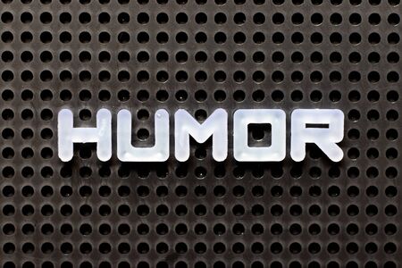 White color alphabet with word humor on black pegboard background
