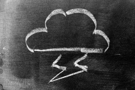 White color chalk hand drawing in cloud with thunder shape on black board background (Concept for link connection)の写真素材