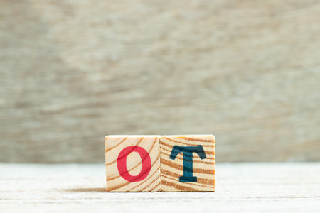 Alphabet letter in word ot (abbreviation for overtime) on wood backgroundの写真素材