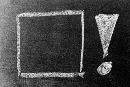 White color chalk hand drawing in exclamation mark with blank space shape on blackboard background