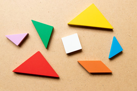 Color tangram puzzle in piece that wait to complete shape on wood backgroundの写真素材