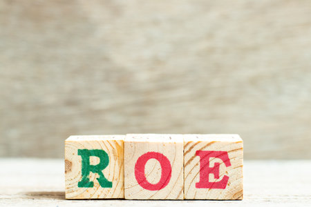 Alphabet letter in word ROE (Abbreviation of Return on equity) on wood backgroundの写真素材