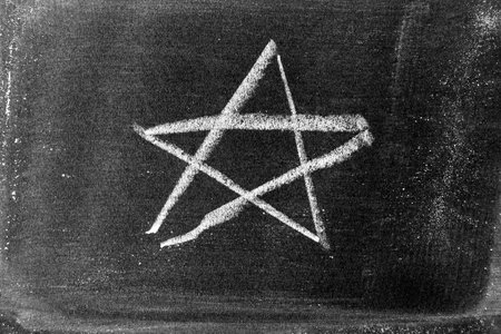 White color chalk hand drawing as star shape on blackboard  or chalkboard backgroundの写真素材