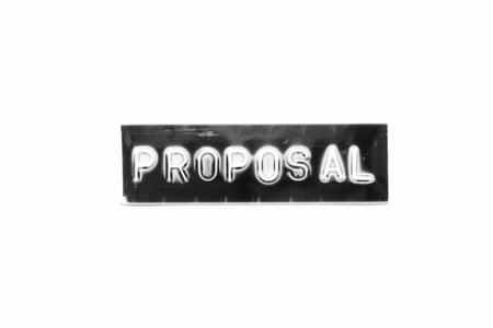 Embossed letter with word proposal in black banner on white paper background