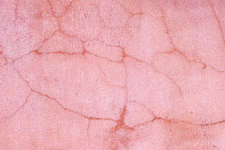 Grunge cracked orange or pink color concrete wall textured background as loft styleの写真素材