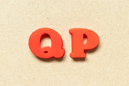 Plastic alphabet letter in word QP (Abbreviation of Quality procedure) on wood background