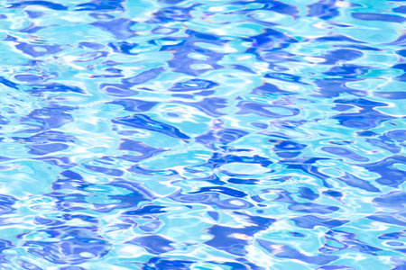 Ripple Water in swimming pool with blue tile floor background