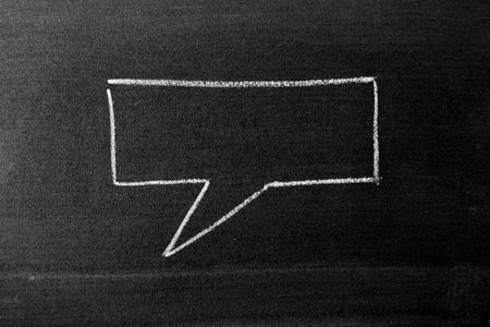 White color chalk hand drawing in square bubble speech shape with blank space on blackboard or chalkboard backgroundの写真素材