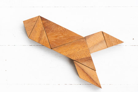 Wood tangram puzzle in rocket or missile shape on white wood backgroundの写真素材