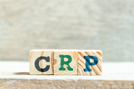 Alphabet letter block in word CRP (abbreviation of C-Reactive Protein Test) on wood background