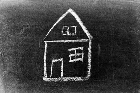White color chalk hand drawing in home or house shape on blackboard backgroundの写真素材