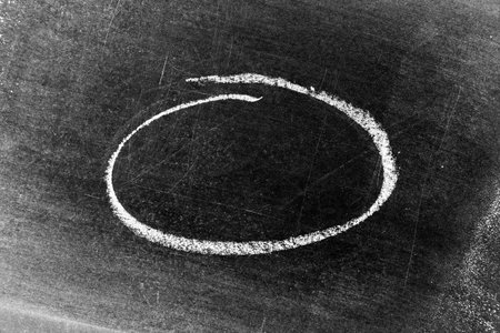 White chalk hand drawing as circle or round shape on blackboard or chalkboard background with copy...