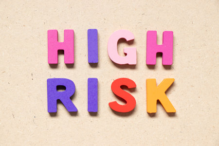 Color alphabet letter in word high risk on wood backgroundの写真素材