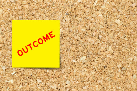 Yellow note paper with word outcome on cork board background with copy space