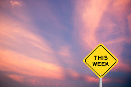 Yellow transportation sign with word this week on violet color sky background