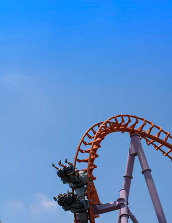 Group of people playing roller coaster red rail in sunny day at amusement park,so very excited.