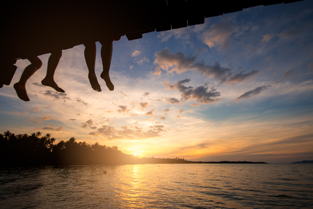 Couple silhouette and watching sun at sunset on the beach.の写真素材