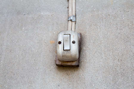 Old white switch on the wall of countryside house.の写真素材