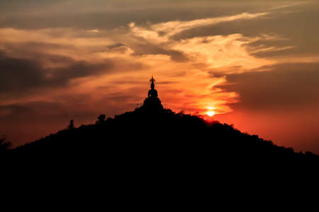 Sunset behind the Buddha on mountain , Ratchaburi Thailand. Process color.の写真素材
