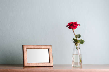 Empty frame and a rose in a vaseの写真素材