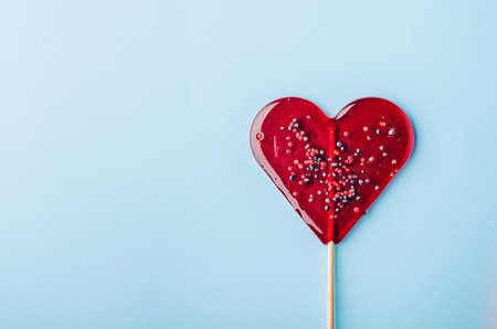Heart lollipop candy on a blue backgroundの写真素材