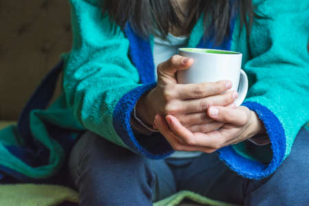 Caucasian woman holding a cup of coffee or teaの写真素材
