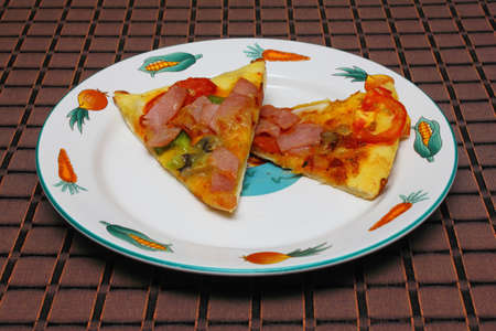 Pizza with tomatoes and cheese on tableの写真素材