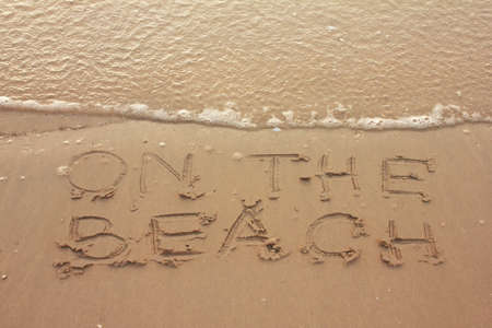 write   ON THE BEACH   on sandの写真素材