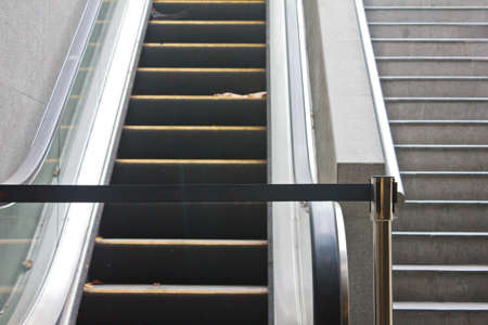 Broken old escalator with black stop tap 