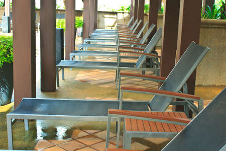 loungers next to a swimming pool   の写真素材