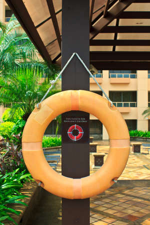 Red lifebuoy with rope on  wooden pillarの写真素材