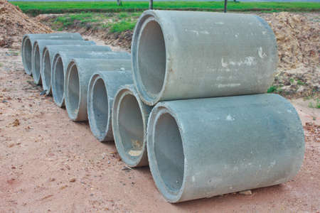 the Stacked concrete drainage pipes on the groundの写真素材