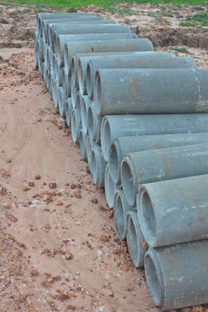 the Stacked concrete drainage pipes on the groundの写真素材