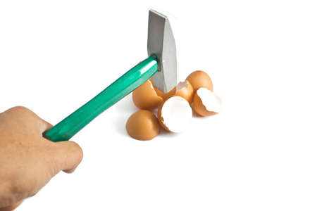 Green hammer cracking egg shell on whiteの写真素材